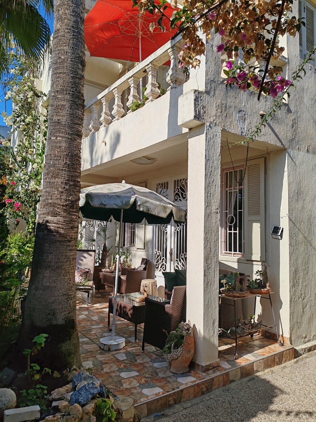 Shaded garden patio beneath the balustraded balcony